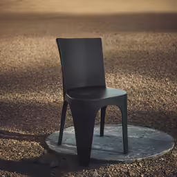 a plastic chair is standing on a circle on a patch of dirt
