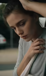 a young woman is sitting and looking down