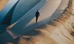 a lone man walks near a large expanse of ice
