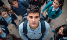 a man in blue shirt standing amongst many other people