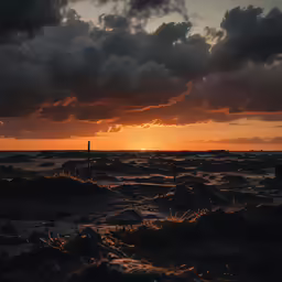 the sun is setting on the ocean with clouds above it