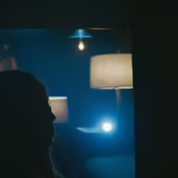 a dark picture of a woman sitting in a chair in the room