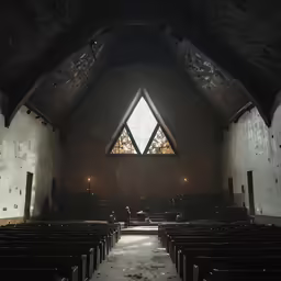 the inside of an empty church with pews and a large window