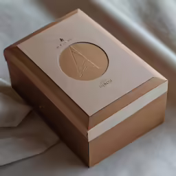 an empty box is sitting on a bed sheet