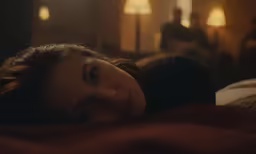 the woman is lying down on a bed in her room