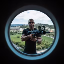 man taking a picture through a scope with his camera