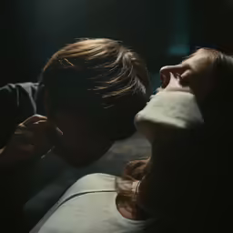 two people are kissing each other in the dark