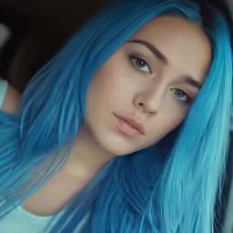 a girl with bright blue hair and pale eyes looks at the camera