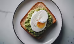 an egg is laying on top of some guacamole in toast