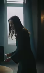 a woman standing in a dark room next to a round table