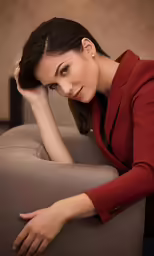 a woman with her hand on the side of a sofa