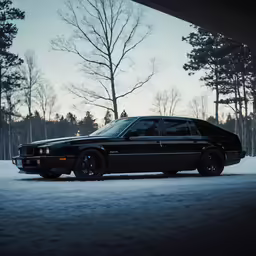 a black car sitting on top of snow covered ground