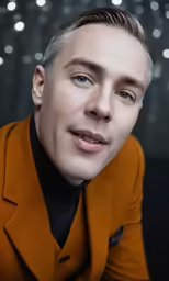 a man in a brown suit poses for a picture