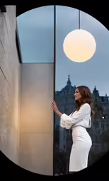 woman standing in the shadow of a round glass window