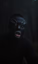 a person in black painted face and hand poses