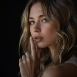 a woman posing with her hand on her face