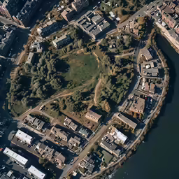 an aerial view of a city area with houses, land and water