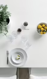 an empty tray has lemons in it with silverware on the side