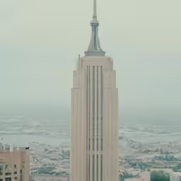 the top of a large skyscraper building looking out onto the water