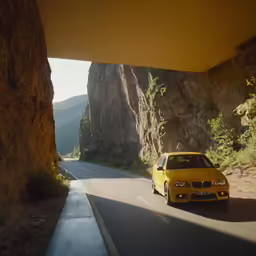 a yellow car on a desert mountain highway