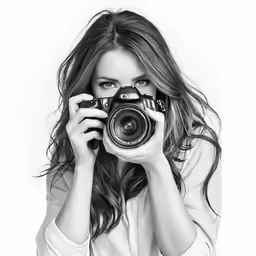 a woman holding a camera in front of her face