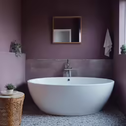 a bathtub in a small room with purple walls