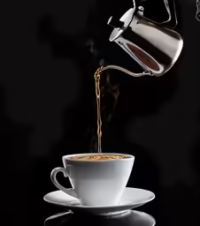 tea being poured into a white coffee cup