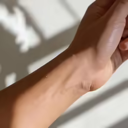 a hand holding something with their arm