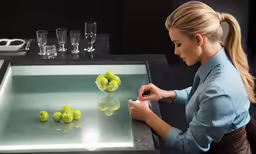 a woman standing at a counter slicing apples