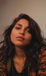 a woman with long dark hair wearing a black shirt