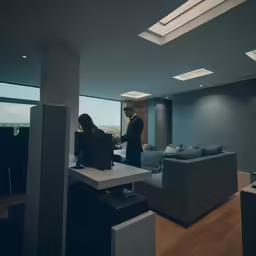 a man standing in an office next to a couch