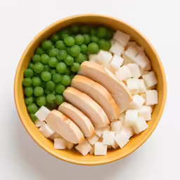 a bowl of food has sliced bread, peas and other vegetables