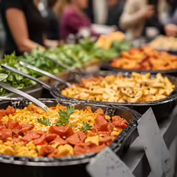 various food dishes in large plates with forks