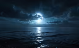 a full moon is shining over the ocean