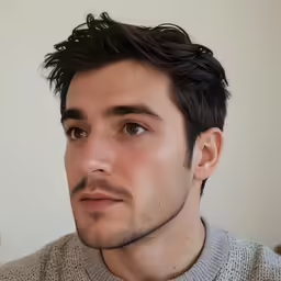 a man with a shaved goatee is staring ahead