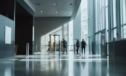people are walking around the elevator of a large building