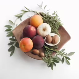 assorted fruits on a tray with green leaves