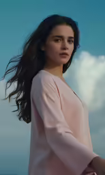 a woman with long hair and wearing pink in the sky