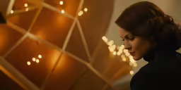 a woman looking at her cell phone, in front of a christmas tree