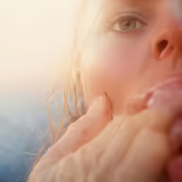 a woman with long hair and one hand on her face