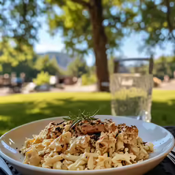 a plate with macaroni and cheese, next to a glass of water