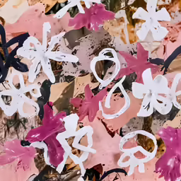 a group of pink and white paper flowers
