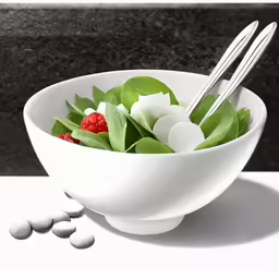 a bowl filled with flowers and leaves sitting on top of a table