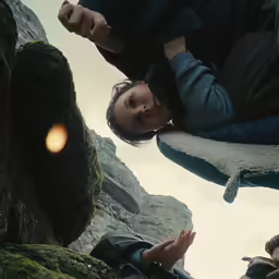 some young men sit at the edge of a cliff