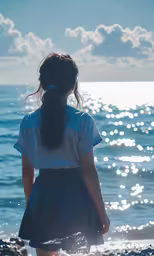 a girl standing on the beach watching the water