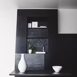 a black and white room features vases on a shelf