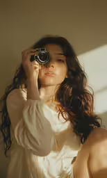 a beautiful woman holding a camera in her hands