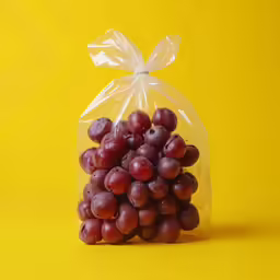 grapes in a clear plastic bag on a yellow background