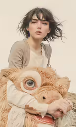 a woman is holding an ugly teddy bear