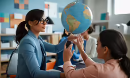 a girl and another woman hold a globe on their shoulders